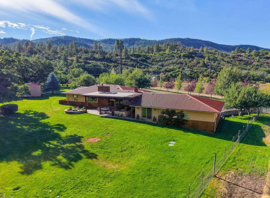 Discover this stunning property nestled against a scenic hillside, offering a perfect blend of indoor and outdoor living.