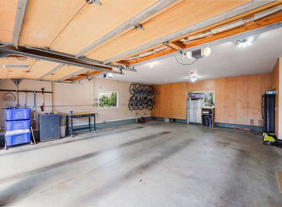 Discover ample storage and organization in this spacious garage, featuring custom wood cabinetry and a dedicated bike rack system.
