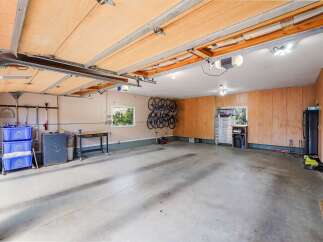 Discover ample storage and organization in this spacious garage, featuring custom wood cabinetry and a dedicated bike rack system.