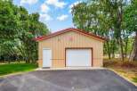 Discover this versatile metal building, perfect for storage or a workshop, featuring a spacious garage door and a convenient side entrance.