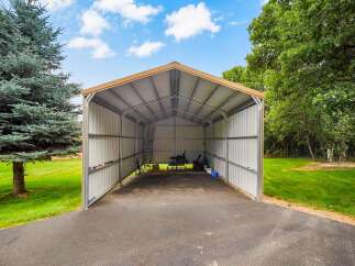 Discover ample storage and protection with this spacious metal carport, perfect for housing vehicles, equipment, or recreational gear.