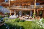 Experience luxury mountain living with this stunning property featuring a spacious wooden deck and a beautifully landscaped garden.