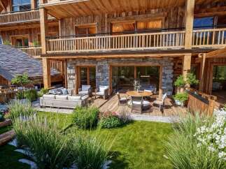 Experience luxury mountain living with this stunning property featuring a spacious wooden deck and a beautifully landscaped garden.