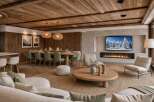 Experience luxury mountain living in this stunning open-concept space, featuring a rustic wooden ceiling and a modern gas fireplace.