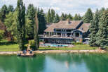 Experience luxury lakeside living in this stunning estate featuring a private dock and a sparkling swimming pool.