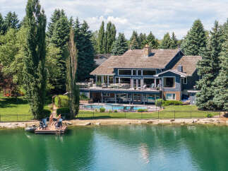Experience luxury lakeside living in this stunning estate featuring a private dock and a sparkling swimming pool.