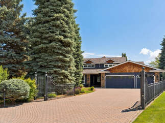 Discover this stunning property featuring a grand entrance with a paved driveway leading to a spacious home.