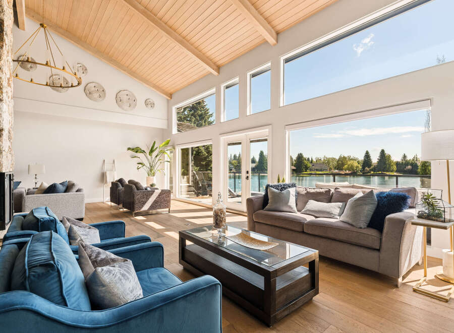 Experience luxurious waterfront living in this stunning home featuring a vaulted wood-beamed ceiling and expansive windows that flood the space with natural light.