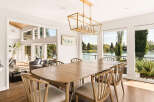 Experience elegant dining with this spacious wooden table and chairs, perfectly situated to capture breathtaking lake views through expansive windows.