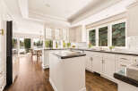 Experience luxury living in this stunning kitchen featuring pristine white cabinetry, elegant granite countertops, and a spacious island perfect for entertaining.