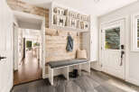 Step into this inviting entryway featuring a stylish built-in bench with storage baskets and a denim jacket hanging on a rustic wood-paneled accent wall.