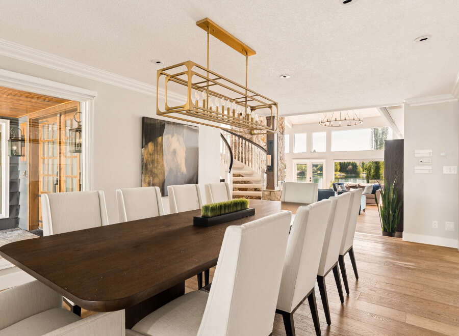 Experience elegant dining in this spacious room, featuring a large, dark wood table surrounded by plush, cream-colored chairs.