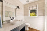 This charming bathroom features a modern vessel sink atop a sleek vanity with a marble countertop.