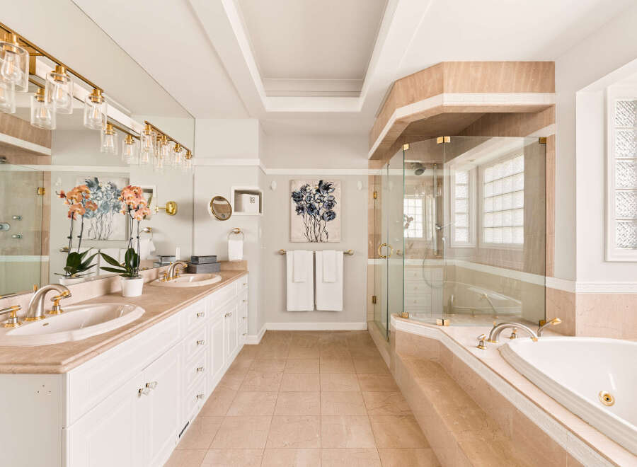 Indulge in luxury with this stunning bathroom featuring a spacious vanity with dual sinks and elegant gold fixtures.