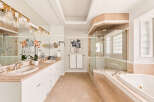 Indulge in luxury with this stunning bathroom featuring a spacious vanity with dual sinks and elegant gold fixtures.