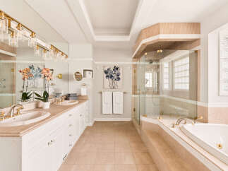 Indulge in luxury with this stunning bathroom featuring a spacious vanity with dual sinks and elegant gold fixtures.