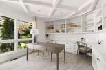 This home office features a coffered ceiling and expansive windows that flood the space with natural light.