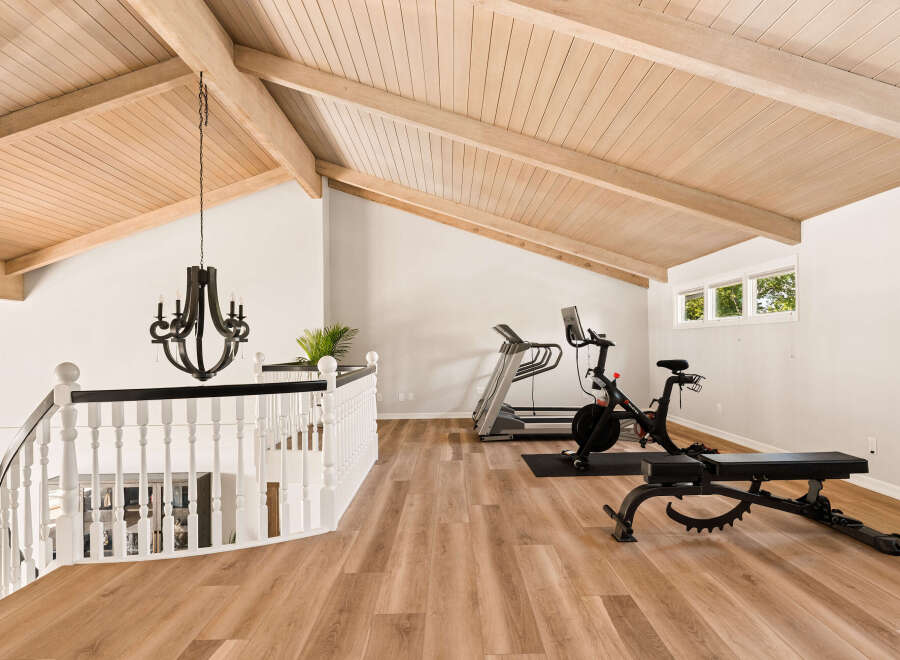Elevate your fitness routine in this spacious loft gym, featuring a Peloton bike and treadmill.
