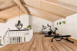 Elevate your fitness routine in this spacious loft gym, featuring a Peloton bike and treadmill.