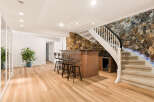This finished basement features a stylish bar area with four stools, perfect for entertaining guests.