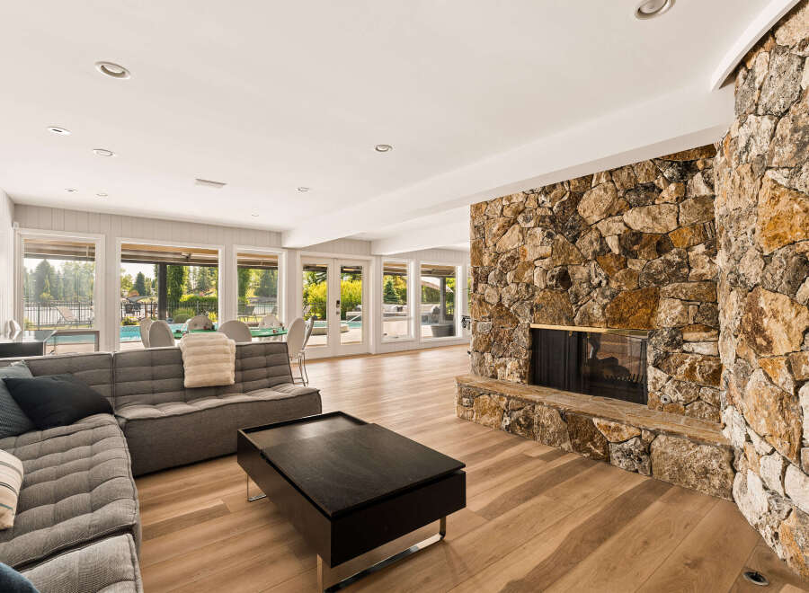 Experience luxurious living in this spacious great room, featuring a stunning floor-to-ceiling stone fireplace as the centerpiece.