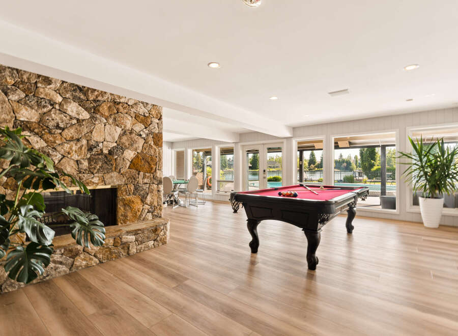 Experience ultimate relaxation and entertainment in this stunning recreational room, featuring a magnificent stone fireplace and a professional-grade pool table.