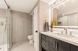 Experience modern luxury in this beautifully appointed bathroom, featuring a sleek glass-enclosed shower and a stylish vanity with a quartz countertop.