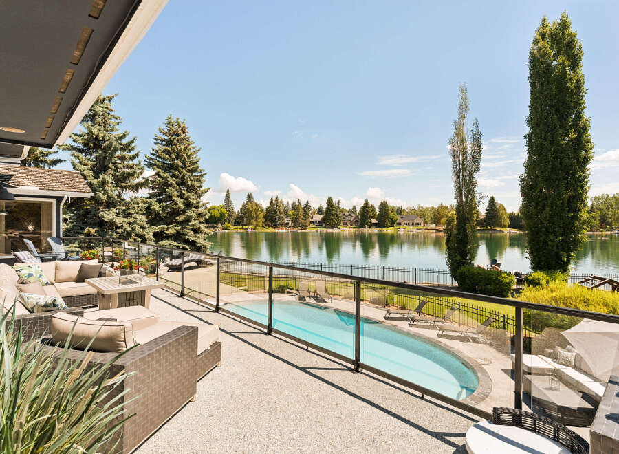 Experience luxury lakeside living with this stunning property featuring a private pool and expansive patio overlooking a serene lake.