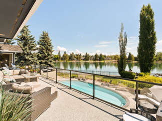 Experience luxury lakeside living with this stunning property featuring a private pool and expansive patio overlooking a serene lake.