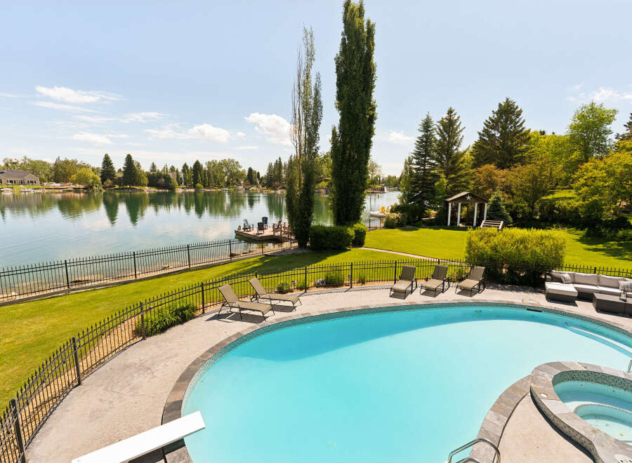 Experience luxury waterfront living with this stunning property featuring a private pool and spa overlooking a serene lake.