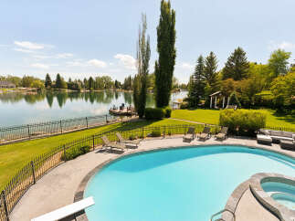 Experience luxury waterfront living with this stunning property featuring a private pool and spa overlooking a serene lake.