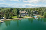 Experience luxury waterfront living in this stunning estate featuring a private dock and two sparkling swimming pools.