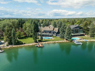 Experience luxury waterfront living in this stunning estate featuring a private dock and two sparkling swimming pools.