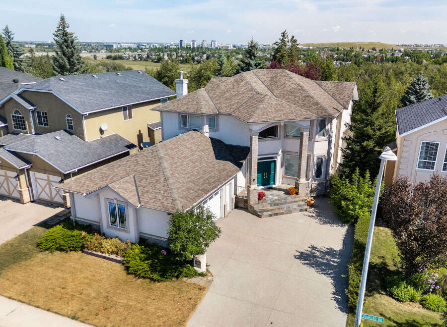 Discover this stunning executive home featuring a grand entrance with double teal doors and a multi-level stone staircase.
