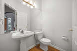 This bright and airy bathroom features a pristine white pedestal sink and a matching toilet, perfect for any modern home.