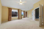 Step into this spacious bedroom featuring a ceiling fan and large windows that offer scenic views.