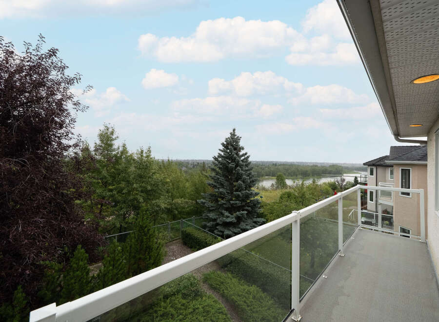 Enjoy breathtaking views from this stunning balcony, featuring a modern glass railing and ample space for outdoor relaxation.