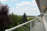 Enjoy breathtaking views from this stunning balcony, featuring a modern glass railing and ample space for outdoor relaxation.