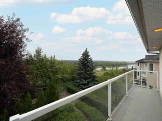 Enjoy breathtaking views from this stunning balcony, featuring a modern glass railing and ample space for outdoor relaxation.