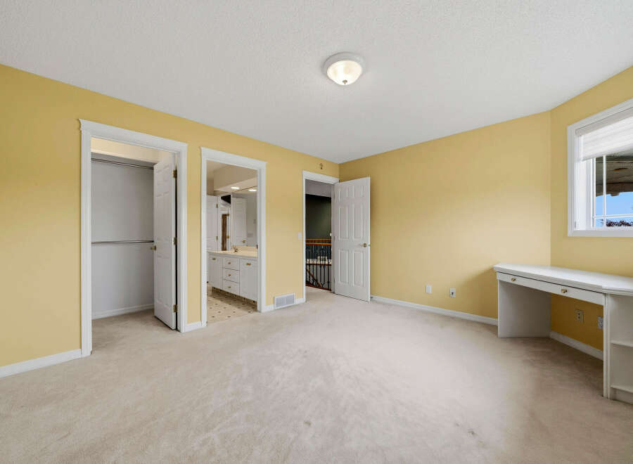 Discover this charming bedroom featuring a spacious layout and a built-in desk, perfect for a home office or study area.