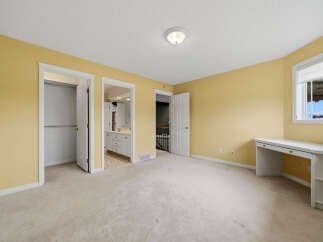 Discover this charming bedroom featuring a spacious layout and a built-in desk, perfect for a home office or study area.