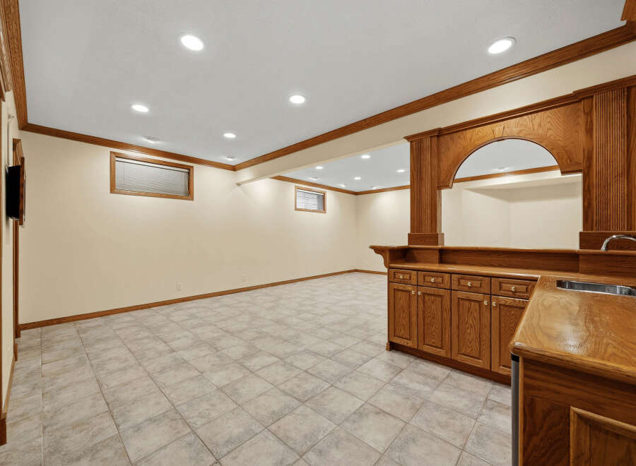 This finished basement features a spacious entertainment area with a built-in bar, perfect for hosting guests.