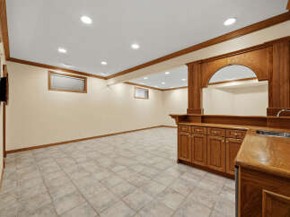 This finished basement features a spacious entertainment area with a built-in bar, perfect for hosting guests.