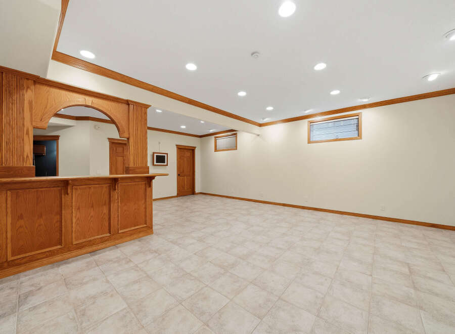 This finished basement features a beautiful custom oak bar, perfect for entertaining guests.
