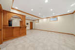 This finished basement features a beautiful custom oak bar, perfect for entertaining guests.