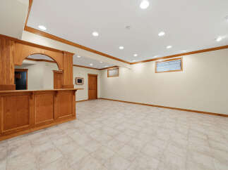 This finished basement features a beautiful custom oak bar, perfect for entertaining guests.