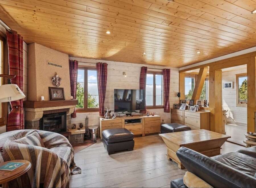 Experience cozy living in this charming mountain retreat, featuring a rustic stone fireplace and warm wooden ceilings.