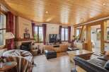 Experience cozy living in this charming mountain retreat, featuring a rustic stone fireplace and warm wooden ceilings.