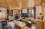 Experience rustic charm in this cozy living room, featuring a warm wood-paneled ceiling and walls.