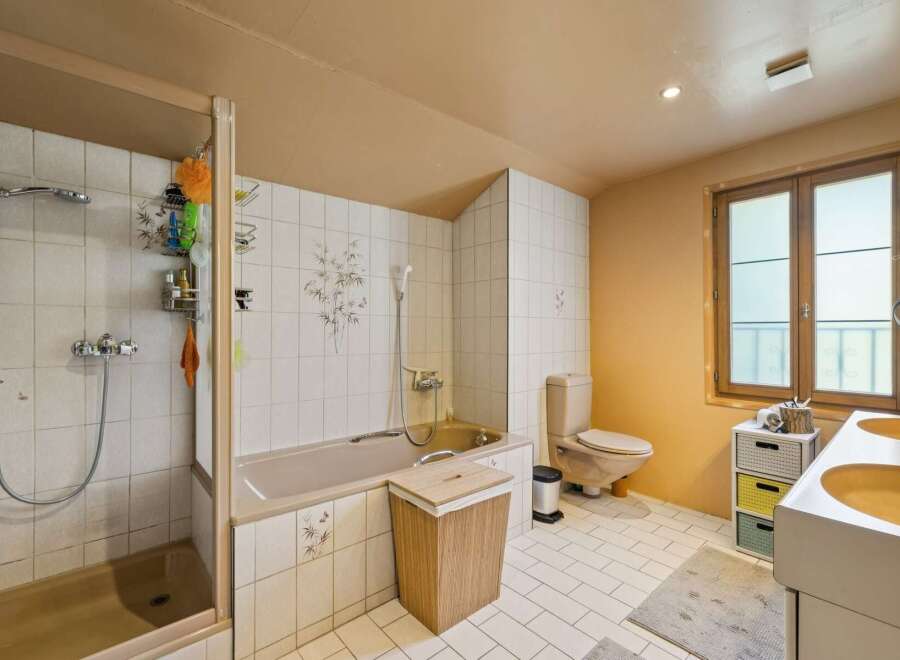This bathroom features a spacious shower and a separate bathtub, perfect for relaxation.